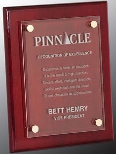 an award plaque is placed on top of a red wooden plaque with the words pinnacle recognition of excellence