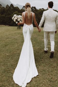 the bride and groom are walking hand in hand