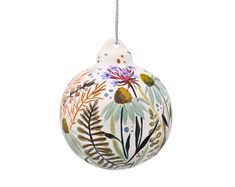 an ornament with flowers and leaves painted on it's side, hanging from a cord