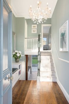 an entry way with stairs and chandelier in the center, leading to another room