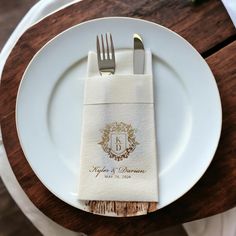 a white plate topped with a fork and knife next to a napkin on top of a wooden table