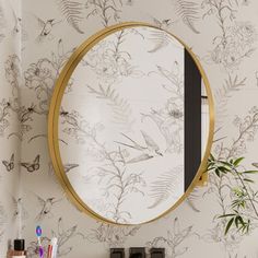 a bathroom with wallpaper and a round mirror