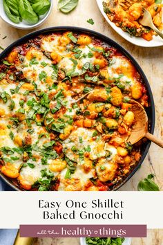 a skillet filled with baked gnocchini and spinach on top of a table