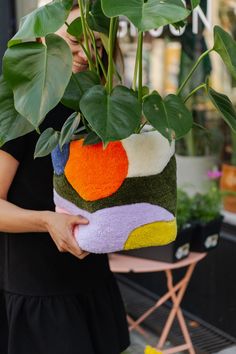 a woman holding a potted plant in her hands