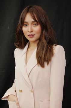 a woman in a pink suit posing for the camera with her hand on her hip