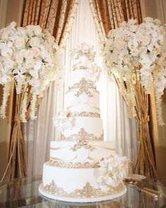 the wedding cake is surrounded by white flowers and greenery on display in this instagram