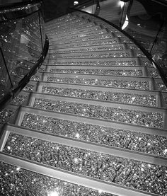 black and white photograph of an escalator going up to the sky at night