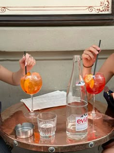 two people sitting at a table with drinks