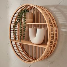 a wooden shelf with two white vases and a potted plant on it's side