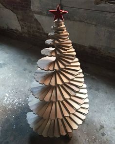 a wooden christmas tree made out of plywood and wood shavings with a star on top