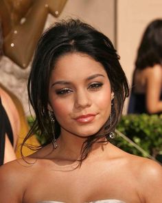 a beautiful young woman in a strapless dress posing for the camera at an event