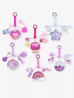 several different types of key chains hanging from the side on a white background with clippings attached to them