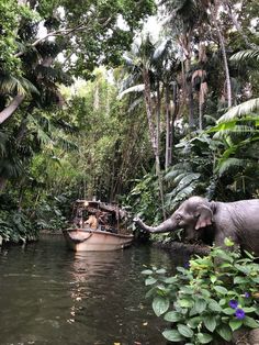 an elephant standing in the middle of a river next to a boat filled with people