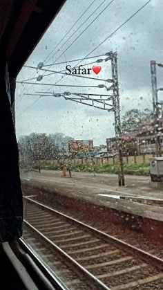 the view from inside a train window looking at tracks and power lines