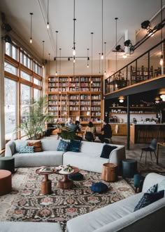 a living room filled with lots of furniture next to a tall book shelf full of books