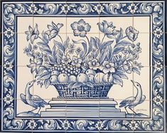 a blue and white tile with flowers in a vase