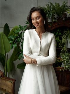 a woman wearing a white dress and jacket