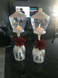 two wine goblets decorated with poinsettis and candles