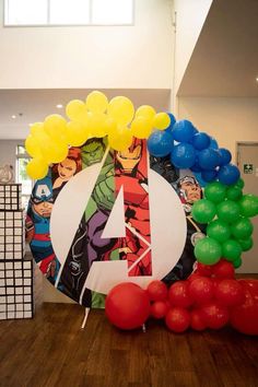 the balloon arch is decorated with balloons and an avengers symbol