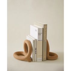 two books are stacked on top of each other in the shape of an oar