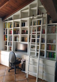 an office with bookshelves, desk and ladder to the ceiling in front of it