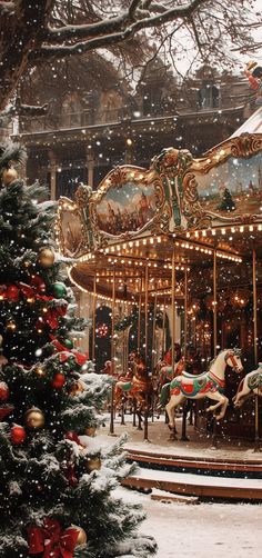 a merry go round in the snow next to a christmas tree