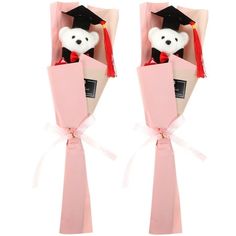 two teddy bears in pink boxes with graduation caps and tassels