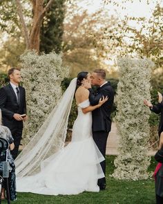 a bride and groom kissing in front of their guests