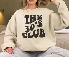 Is someone turning 30 and you're looking for a unique and special 30th birthday gift? Look no further than this sweatshirt with the word 'The 30's Club' in a retro font on the front! This comfortable and stylish garment is perfect for anyone entering their 30's. Not only is it a great way to show your love and appreciation, but it's also a great way to celebrate a milestone in someone's life. **DETAILS** This Gildan 18000 unisex sweatshirt is cozy and soft, the comfiest sweatshirt you will own! It's comfortable and flattering for both men and women.  - Unisex sizing, please refer to sizing chart in listing photos - 50% cotton, 50% polyester - Medium fabric weight   **PRINTING** - DTG (Direct To Garment) Printed    **CARE** - Machine wash: warm (max 40C or 105F) - Do not iron directly on pr Birthday Sweater, 20th Birthday Gift, Turning 20, Birthday Sweatshirt