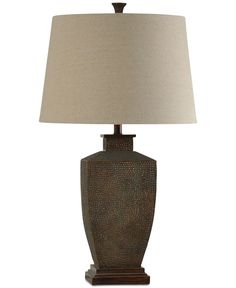 a lamp that is sitting on top of a wooden base with a beige shade over it