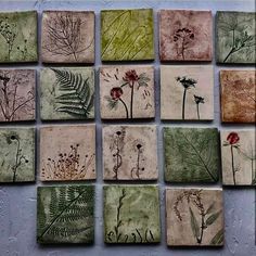 a bunch of tiles with flowers and plants painted on them in different shades of green