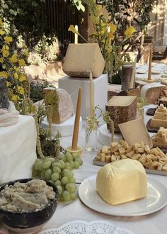 a table topped with lots of different types of cheeses and crackers on top of plates