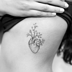 a heart tattoo on the back of a woman's stomach