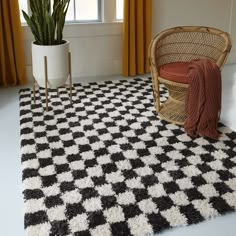 a black and white checkered area rug in front of a window