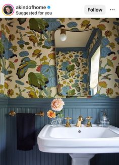 a white sink sitting under a bathroom mirror next to a wall mounted faucet