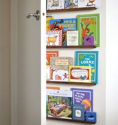 the door is open and there are many children's books on the shelves in this room