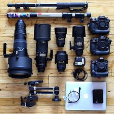 many cameras and accessories are laid out on the floor