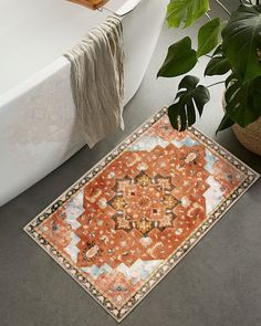 a bath tub sitting next to a rug on the floor