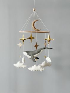 an orca whale and stars hanging from a mobile