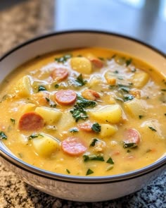 a bowl of soup with sausage, potatoes and spinach