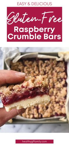 a hand holding a piece of raspberry crumble bar