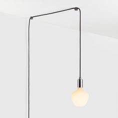 a light that is hanging from the ceiling with a long black cord attached to it