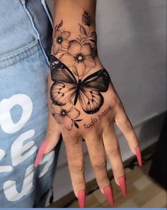 a woman's hand with a butterfly tattoo on it