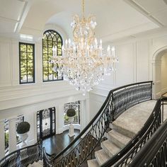 an ornate staircase with chandelier and windows