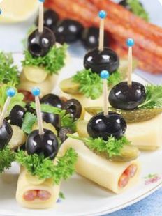 small appetizers with olives, cheese and lettuce are on a plate