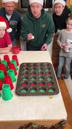 a group of people standing around a table with cupcakes in front of them