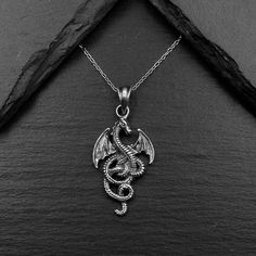 Real 925 Sterling Silver Dragon Charm Necklace This simple yet elegant necklace features a sterling silver Dragon on a Dainty Sterling silver cable chain. Charm Measures 30 x 14 mm Jewelry will come in a gift box * Please read shop policy before placing an order * *JEWELRY CARE* Sterling Silver will tarnish over time, but to help keep your jewelry looking beautiful - Clean with a soft dry cloth after wear and store it inside an airtight bag or container. Remember to remove your jewelry when: * Applying lotion or sunscreen * Applying perfume * Taking a shower / bath * Working out Sterling Silver Charm Necklace With Oxidized Finish For Gift, Sterling Silver Pendant Charm Necklace With Oxidized Finish, Dragon Design Amulet Necklace, Unique Dragon Design Jewelry Pendant, Silver Dragon Design Sterling Silver Necklace, Applying Perfume, Fantasy Dragon Pendant Jewelry, Dragons Clothes, Fantasy Pendant