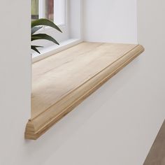 a wooden shelf sitting next to a window in a white walled room with a potted plant on the ledge