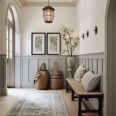 a room with two benches and some pictures on the wall above it, along with vases filled with flowers