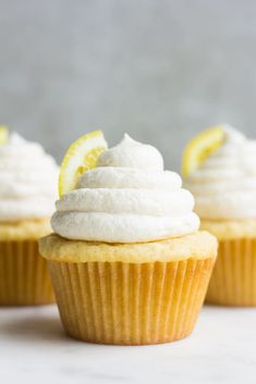 two cupcakes with lemon and white frosting